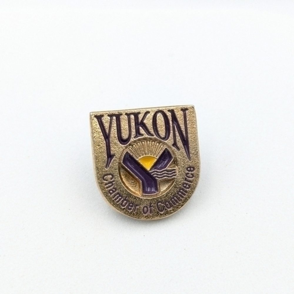 Yukon Chamber Of Commerce gold tone and purple enamel pin.